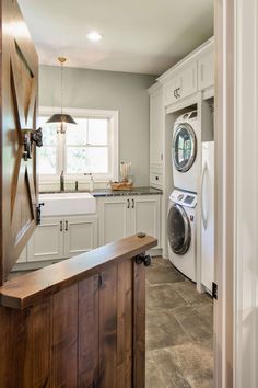 a washer and dryer in a kitchen with tile flooring, cabinets and counter tops