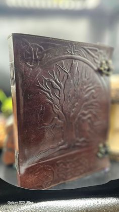 a brown leather book sitting on top of a table