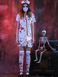 a woman in a white dress with red paint on her face standing next to a skeleton