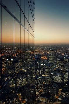 an aerial view of the city at night from high up in the building's windows