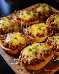 several stuffed buns filled with meat and cheese on a cutting board