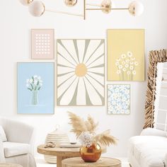 a living room filled with white furniture and pictures on the wall above it's coffee table