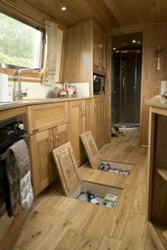 the inside of a motor home with wood flooring and cabinets, including an open sink