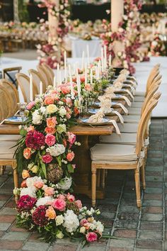 a long table with flowers and candles on it