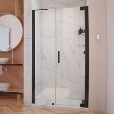 a glass shower door in a bathroom next to a sink and mirror on the wall