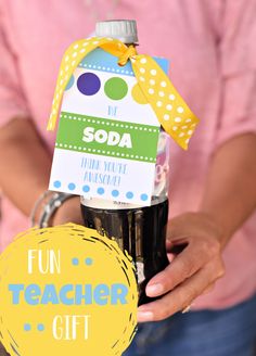 a person holding a soda bottle with a sign on it that says fun teacher gift