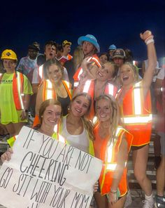 a group of people in safety vests holding a sign that says i'm you are not cheering go get it with work now