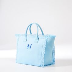 Bold, bright and generously sized, this beach-ready canvas bag has smart details like zipper closure, fringed edging, soft lining, two interior pockets and colors that spark joy. Made by Monogram Mary, from durable canvas, the two-toned embroidered monogram adds a personal touch.  17" w x 10.5" d x 8.5" h  Handle drop: 5"  Three interior pockets. Double open: 9" w x 5" h; Zipper: 7" w x 5.5" h  Canvas.  Spot clean.  Imported.  Monogramming is embroidered   Ships directly from the designer. Ships Blue Canvas Bag For The Beach, Blue Fringed Bags For Vacation, Blue Canvas Tote Beach Bag, Blue Canvas Beach Tote Bag, Blue Canvas Bags For Weekend, Blue Canvas Bag For Summer, Blue Canvas Weekend Bag, Summer Blue Canvas Bag, Summer Blue Fringe Bag