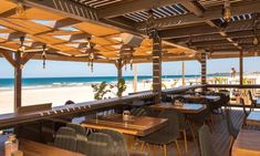 an outdoor dining area overlooking the beach and ocean