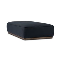 a black ottoman sitting on top of a white floor