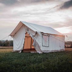 a white tent sitting on top of a lush green field