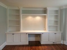 an empty room with white built in cabinets