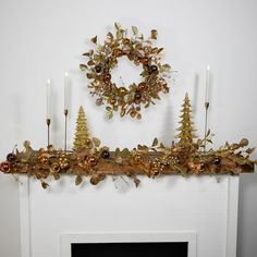 a fireplace mantle decorated with gold christmas decorations