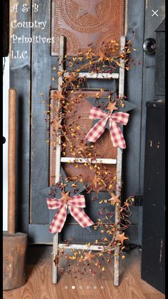 an old ladder is decorated with red and white gingham bows for the front door