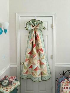 the door is open to show a quilted blanket hanging from it's side