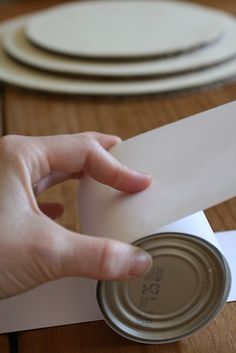 a person is opening a can on top of a table with plates and napkins