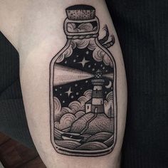 a bottle with a lighthouse in it on the arm is filled with water and stars