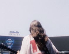 a man holding a guitar while standing in front of a stadium