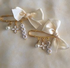 two hair clips with pearls and bows on them, one has the word bride written on it