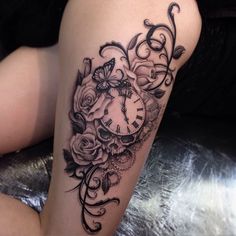 a woman's thigh with a clock and roses tattoo on her leg that is black and white