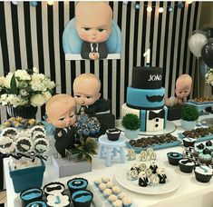 a table topped with cakes and cupcakes covered in frosting next to pictures of babies