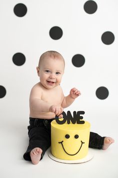 a baby sitting on top of a yellow cake