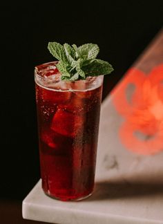 a tall glass with ice and mint garnish