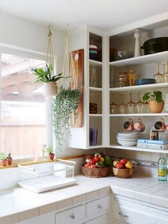 the kitchen is clean and ready for us to use it's shelves are filled with dishes