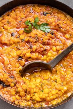 a pan filled with chickpeas and garnished with cilantro leaves