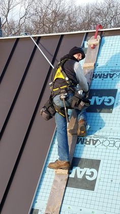 a man working on the side of a building