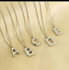 The Bubble initial letter necklace.  CHARM IS STAINLESS STEEL & NECKLACE IS STAINLESS STEEL It comes with a 20 inches cable chain with lobster claw closure.  The bubble letter charm is approximate 1 inch This is fashion jewelry please take of it as such.  Avoid contact with lotion, body oils, sprays, perfumes, and other household chemicals or cleaners. To clean use a jewelry polishing cloth or a polishing lotion after wearing in order to keep your jewelry bright and beautiful. You should store your beloved jewelry in a cool dry place. Trendy Silver Necklaces For Personalized Gifts, Trendy Silver Necklace For Personalized Gift, Trendy Initial Pendant Necklace For Mother's Day, Trendy Personalized Silver Necklaces, Trendy Initial Pendant Charm Necklace For Mother's Day, Trendy Silver Charm Necklace For Personalized Gift, Silver Initial Necklace For Birthday, Trendy Silver Letter Beads Necklace, Silver Jewelry With Letter Beads