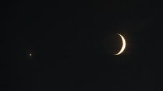 two crescents are seen in the night sky with one half moon visible behind them