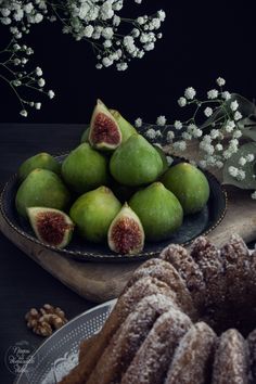 a plate with some fruit on it next to a bundt cake and white flowers