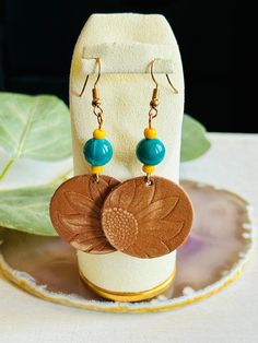 These adorable leather sunflower earrings are hand made in the USA.  Add a little bit of fun to your wardrobe ladies!  These earrings are the perfect accessory for a night out on the town or with a pair of your favorite jeans.  This earring is a great gift for any woman.  The earring is length 2" Due to the assorted nature of this item, unique variations in color and print yield one-of-a-kind pendants. The pendant you receive may vary in style, print, and color from what is pictured. Yellow Leather Jewelry For Gifts, Hand Tooled Adjustable Dangle Earrings, Adjustable Nickel-free Flower Earrings For Everyday, Everyday Adjustable Dangle Flower Earrings, Adjustable Sunflower Design Earrings For Summer, Leather Sunflower, Sunflower Pendant, Sunflower Earrings, Pendant Earrings