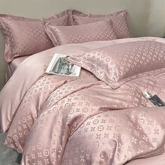 a bed with pink comforters and pillows on it