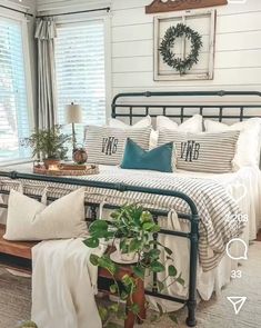 a bed room with a neatly made bed and plants on the nightstands next to it