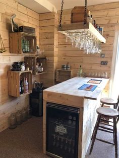 a kitchen with wooden walls and an island in the middle, filled with wine glasses