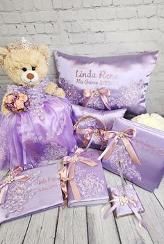 a teddy bear sitting next to some purple gifts