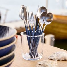 forks and spoons in a glass on a table