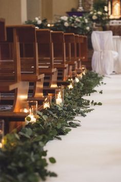 rows of chairs lined up with candles and greenery