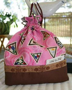 a small pink bag sitting on top of a table next to a bird figurine