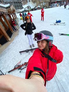 a woman taking a selfie in the snow with her skis and goggles on