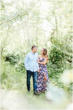 an engaged couple walking through the woods together