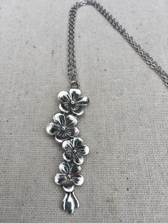 This is so unique and pretty!  Elongated flower pendant necklace.  It has incredible detail and design.  The perfect necklace for any botanical lover.  It would make a very lovely gift.The pendant is made from allergy free plated silver and measures 2 1/4” long by 1/2” wide.  It hangs from a simple 18” stainless steel necklace chain with a lobster clasp.  I have matching earrings in my shop, if you would like the whole set.  Here is the link............ https://etsy.me/2RL7mtu Thanks for stoppin Metal Flower Charm Necklaces, Dainty Metal Necklace With Flower Charm, Delicate Silver Jewelry With Flower Decoration, Metal Flower Necklace For Gift, Adjustable Metal Necklace With Flower Charm, Metal Jewelry With Flower Charm And Pendant, Silver Flower Jewelry With Adjustable Chain, Delicate Silver Flower Charm Necklace, Silver Delicate Flower Charm Necklace