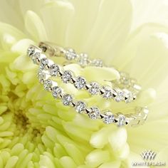 two diamond bracelets sitting on top of a flower