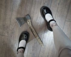 a woman standing on top of a hard wood floor next to a hammer and shoe