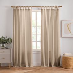 a living room with white walls and beige curtains