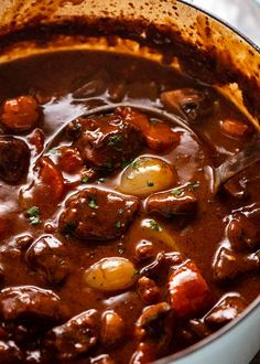 a pot filled with meat and potatoes on top of a table