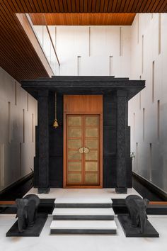 an entrance to a building with steps leading up to it and two elephants on the floor