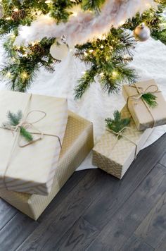 three wrapped presents under a christmas tree